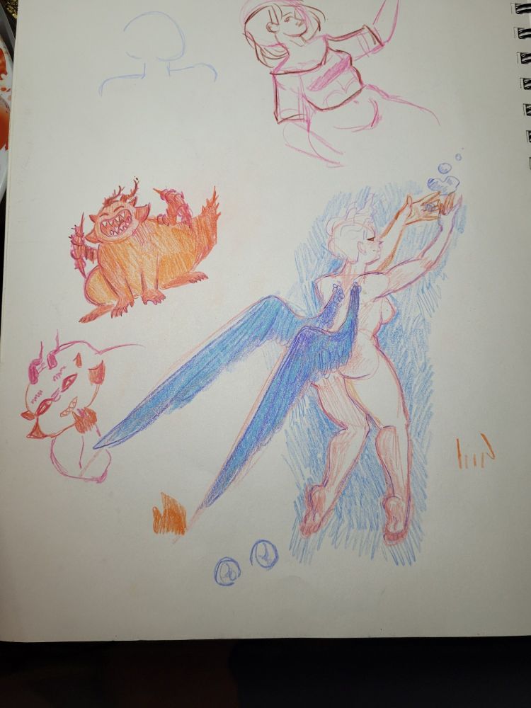 A photo of an open sketchbook with colorful drawings including a woman with blue wings and a round red dragon