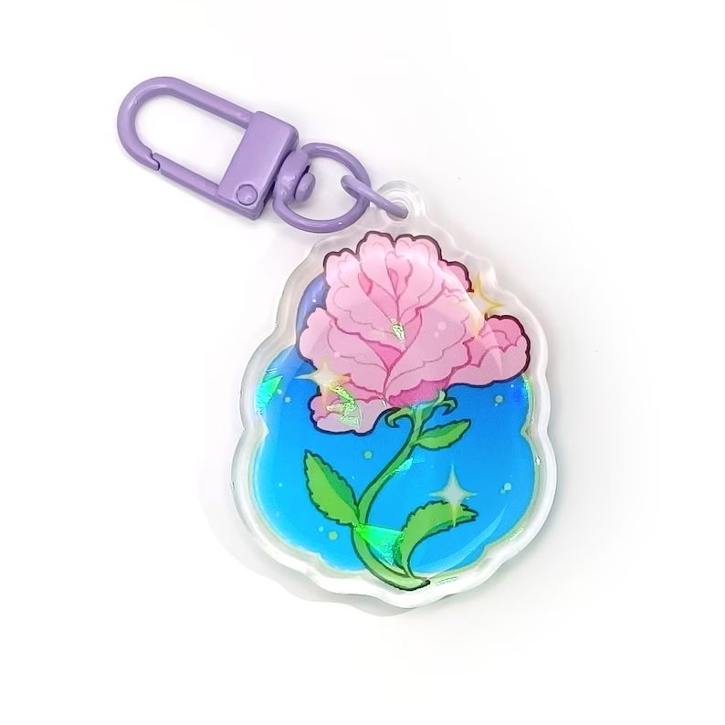 charm of a pink rose with a cyan to blue backdrop, the keychain is purple