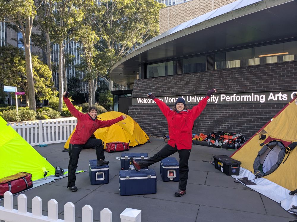 Creativity experts Laura and Mon dressed in polar explorer gear in front of three yellow tents. 