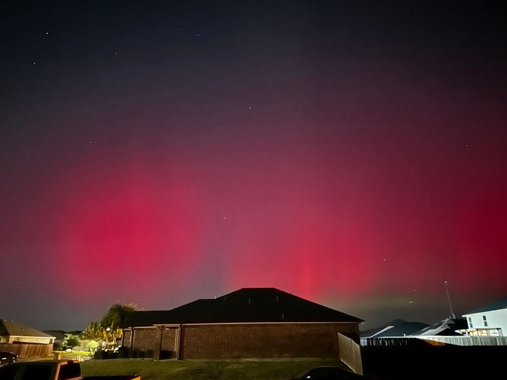 Image shows the Aurora borealis in front of my house. This image shows the borealis in phases of light pink almost red, and green. 