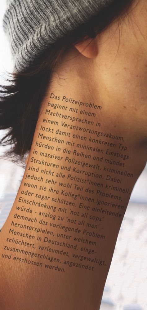 das vorherige foto jedoch stark bearbeitet. das 1312-tatto ist nun weg, stattdessen ist der hals nun unnatürlich in die länge gezogen und auf vielen zeilen  ist nun die im urspürglichen post vorgeschlagene polizeikritik tätowiert"
