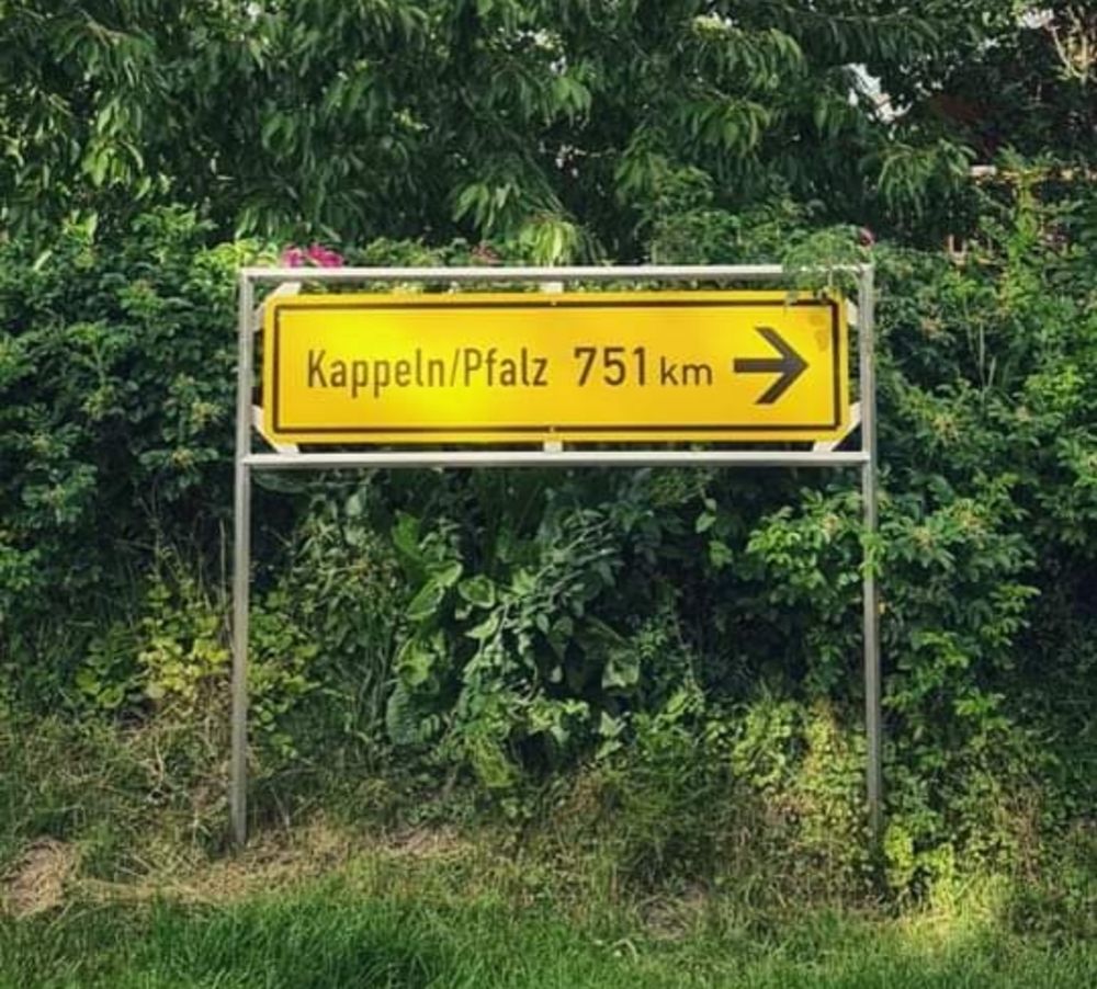 Gelbes Straßenschild als Wegweiser mit der Aufschrift "Kappeln/Pfalz 751 Kilometer"