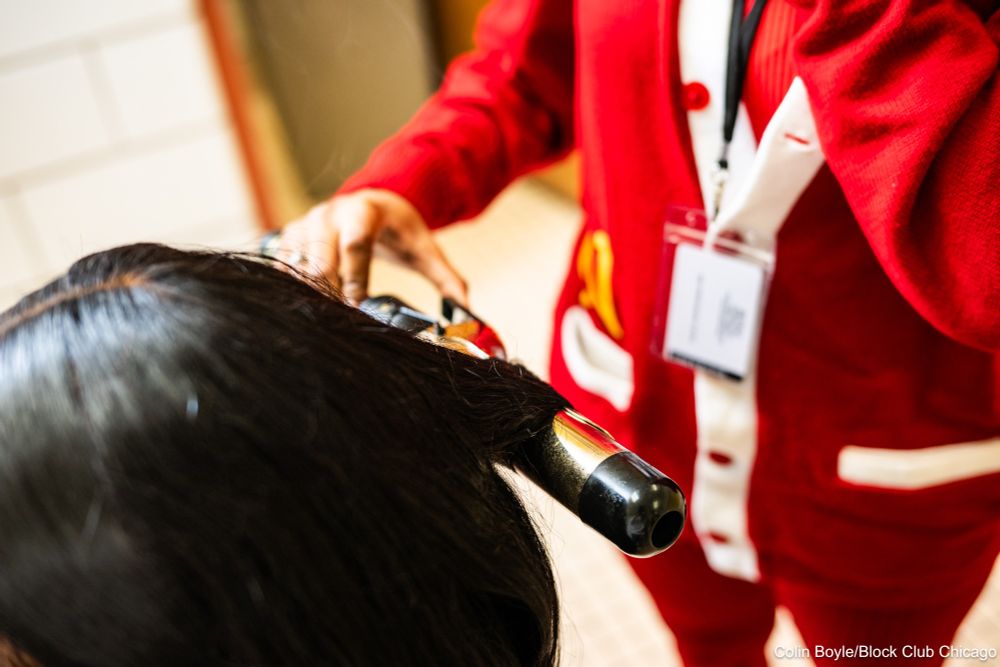 Jessica Thurmond, a student at North Lawndale College Prep, curls her classmate Jada Ervin’s hair at school on March 18, 2025. Credit: Colin Boyle/Block Club Chicago
