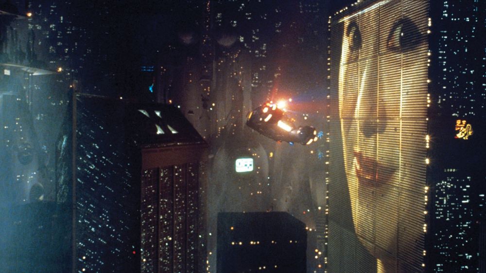 An image of a cityscape with a flying police car in Blade Runner (1982).