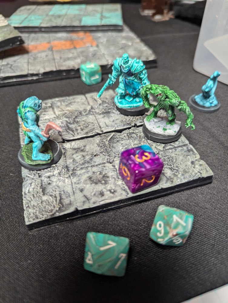 Miniature monsters battling it out on a dungeon tile