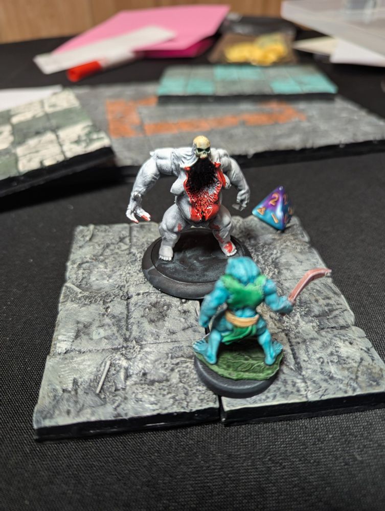 Frogman mini facing down a giant corpse creature 