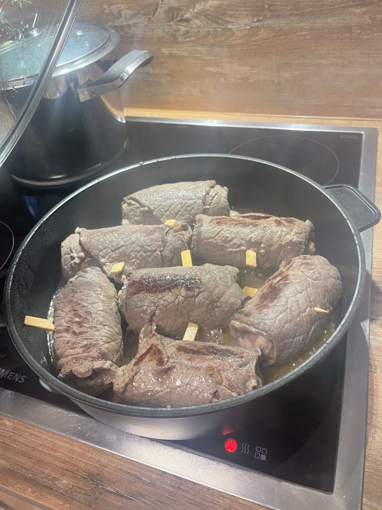 Rindsrouladen in einer Pfanne beim anbraten. 