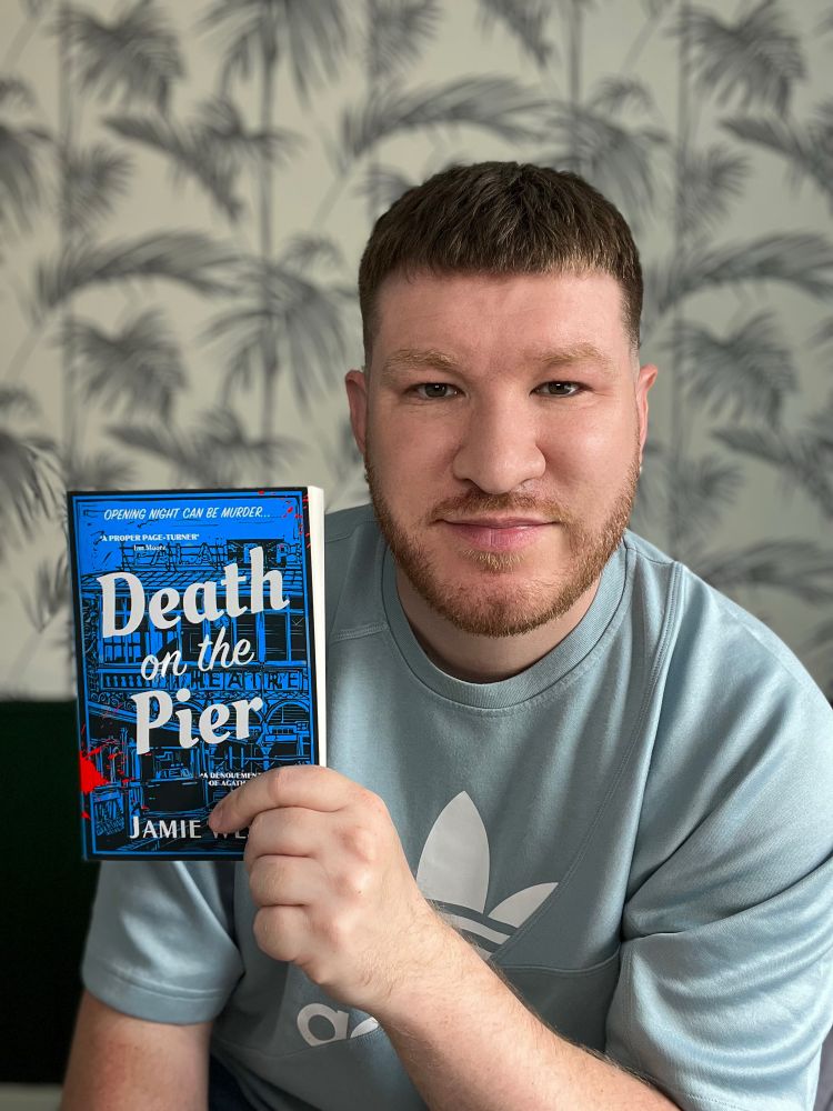 The author holding a copy of his book Death on the Pier