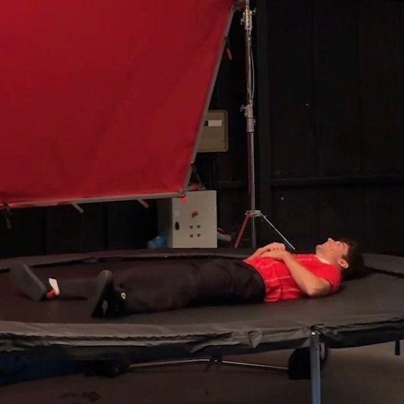 Charles leclerc laying down on a trampoline during a photo shoot 