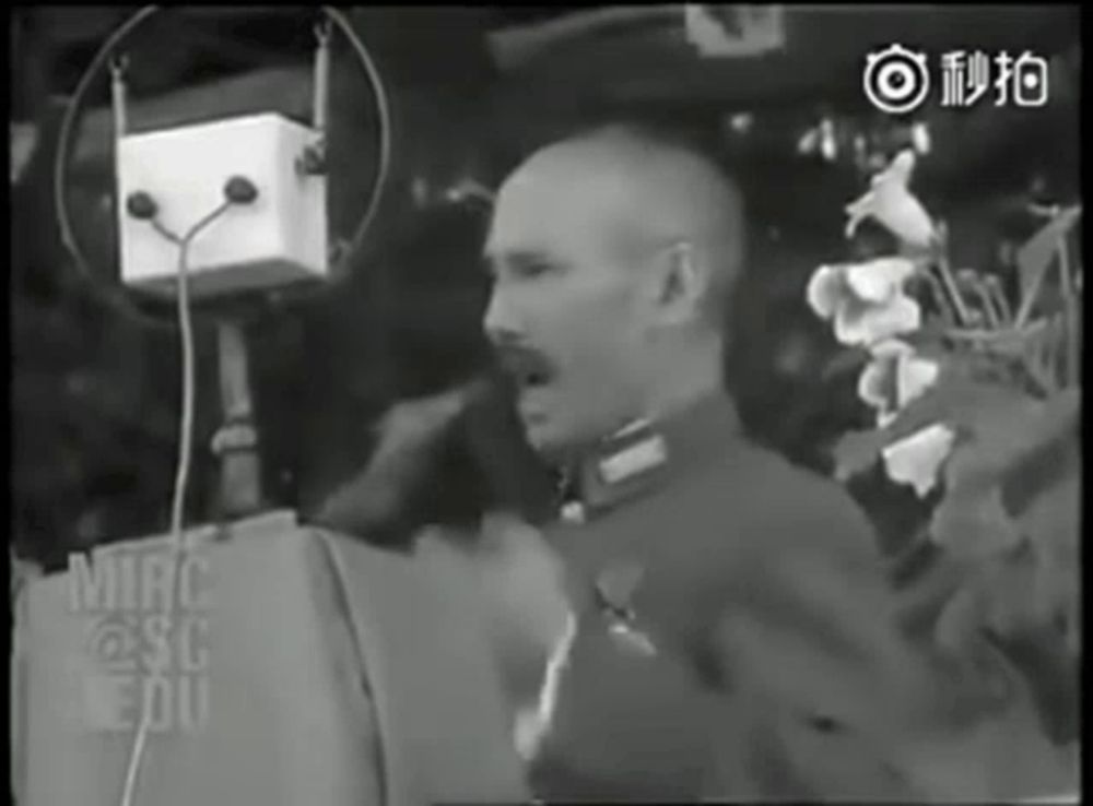 a black and white photo of a man speaking into a microphone with the word mirac on the bottom