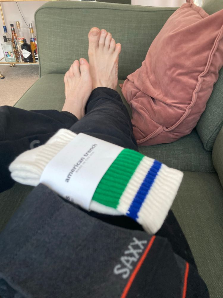Size twelve feet with new socks packages in the foreground.