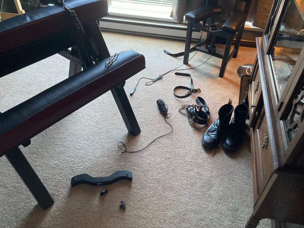 A dungeon room with kink gear scattered all over the floor.