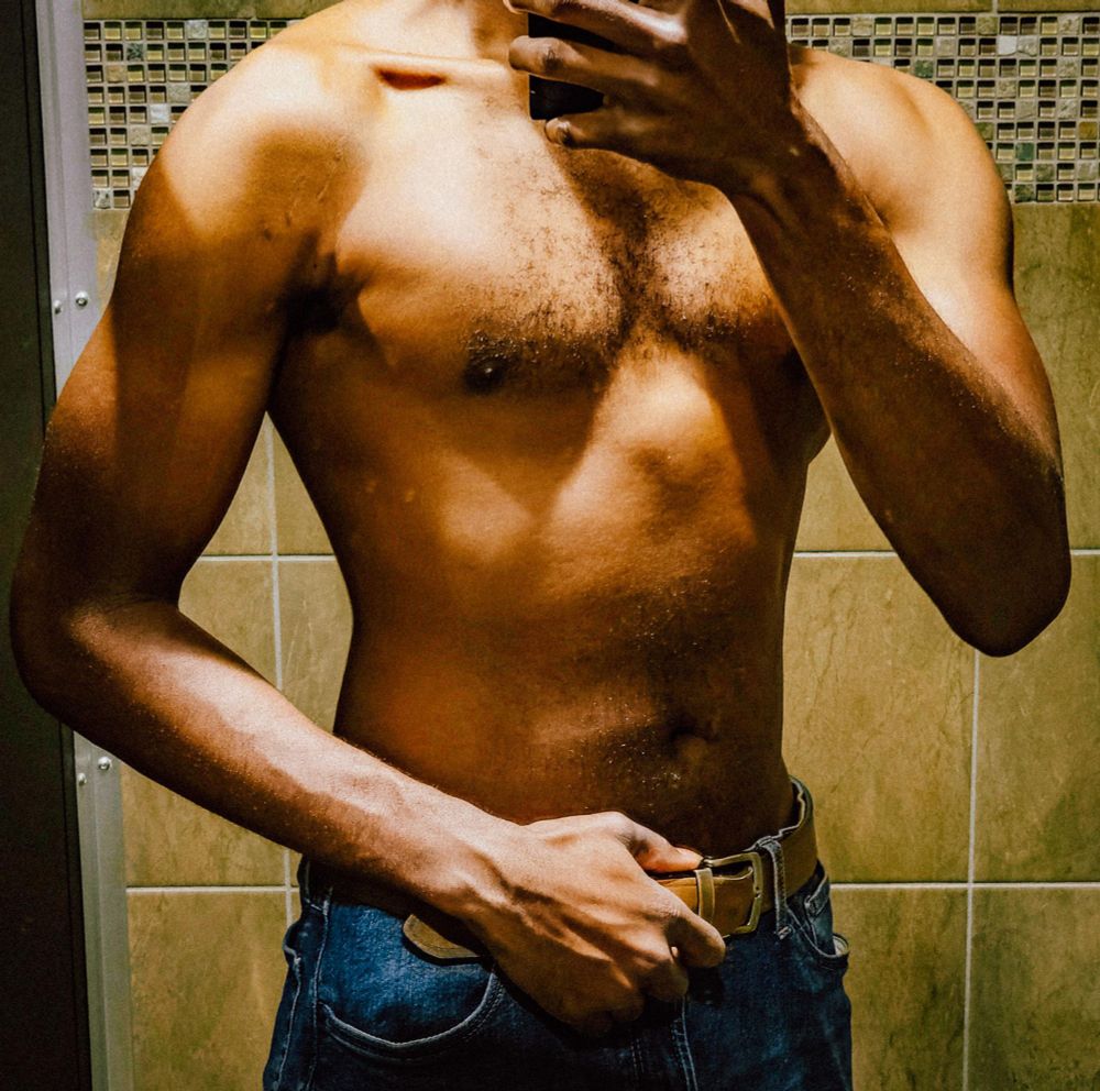 Photo of me without a shirt on in a bathroom appreciating muscle gains