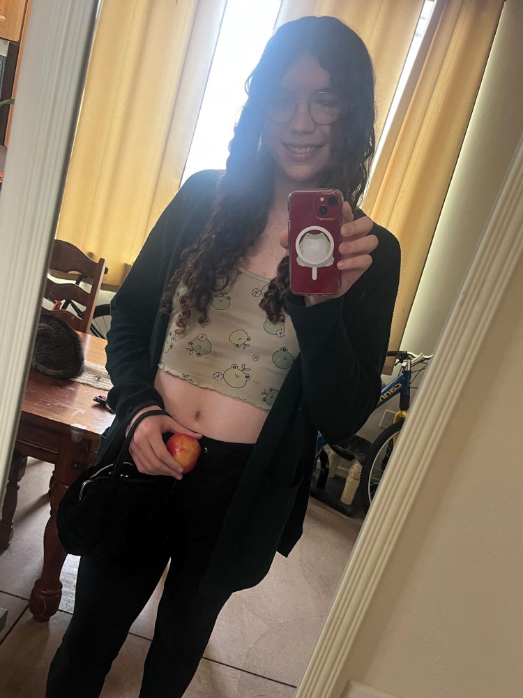 puddle selfie with an apple in hand and purse on faer wrist