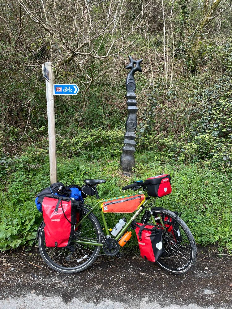 Touring bike in front of National Cycle Network signs