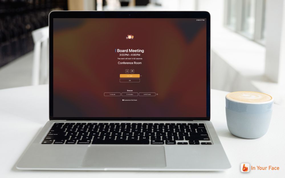 A MacBook showing a full-screen meeting alert