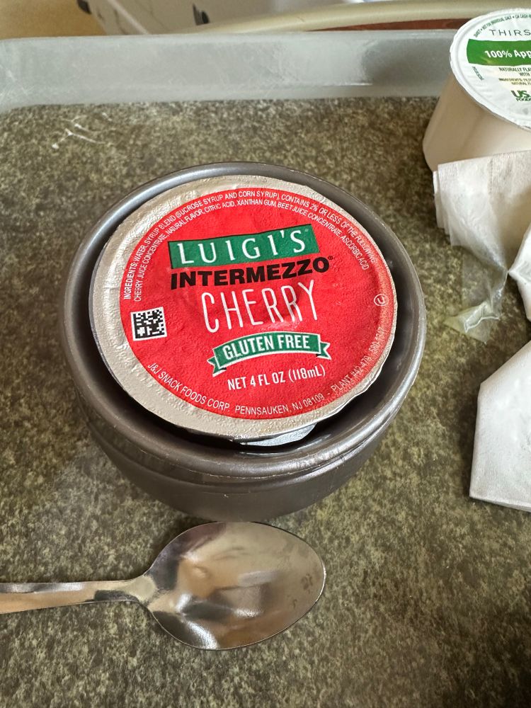 A hospital service dish holding a cup of Luigi’s Italian ice