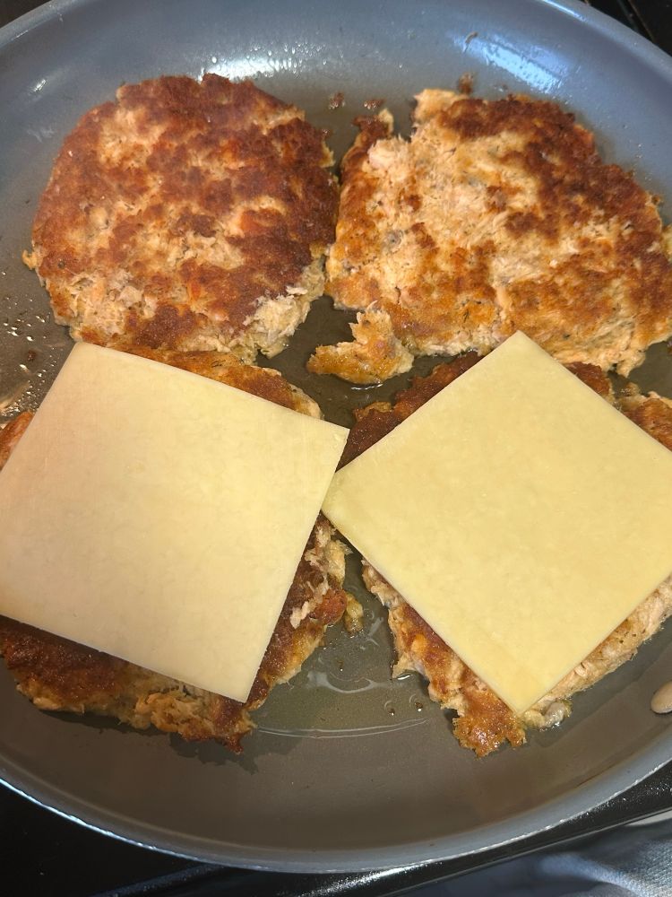 Salmon burgers cooking in a skillet