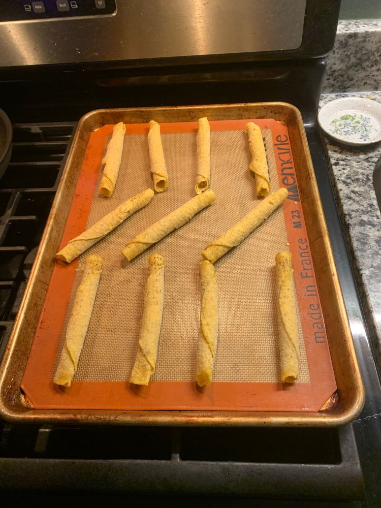 A baking sheet with eleven frozen taquitos on it; usually the box comes with only the listed twenty so I’ll make ten at a time