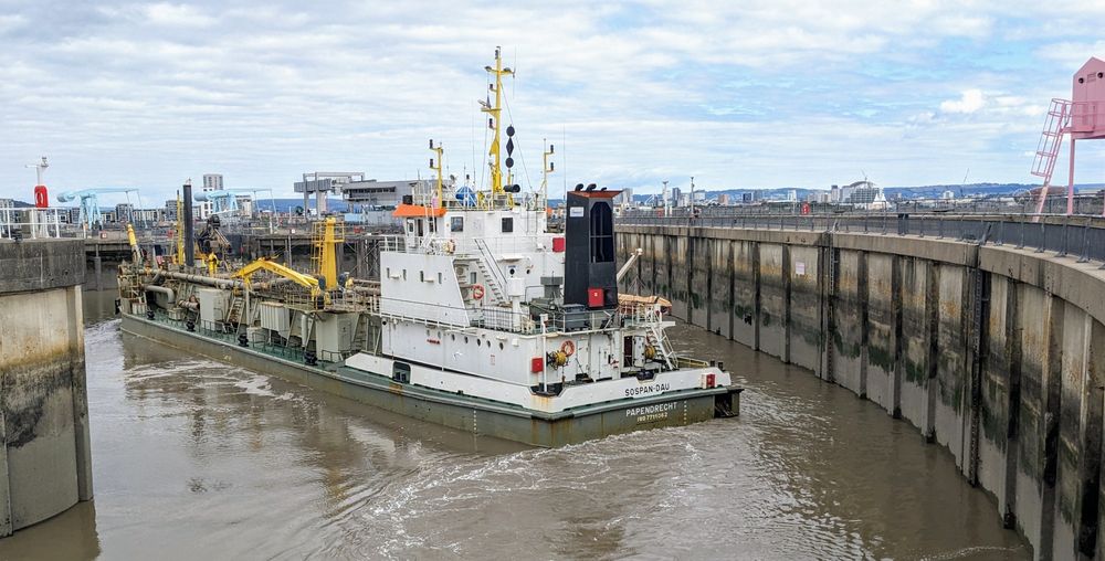 The dredger makes it through. From this angle it looks as though it was easy, but this thing was BIG and the turning angle was AWKWARD and NARROW. Nice work, Drive!