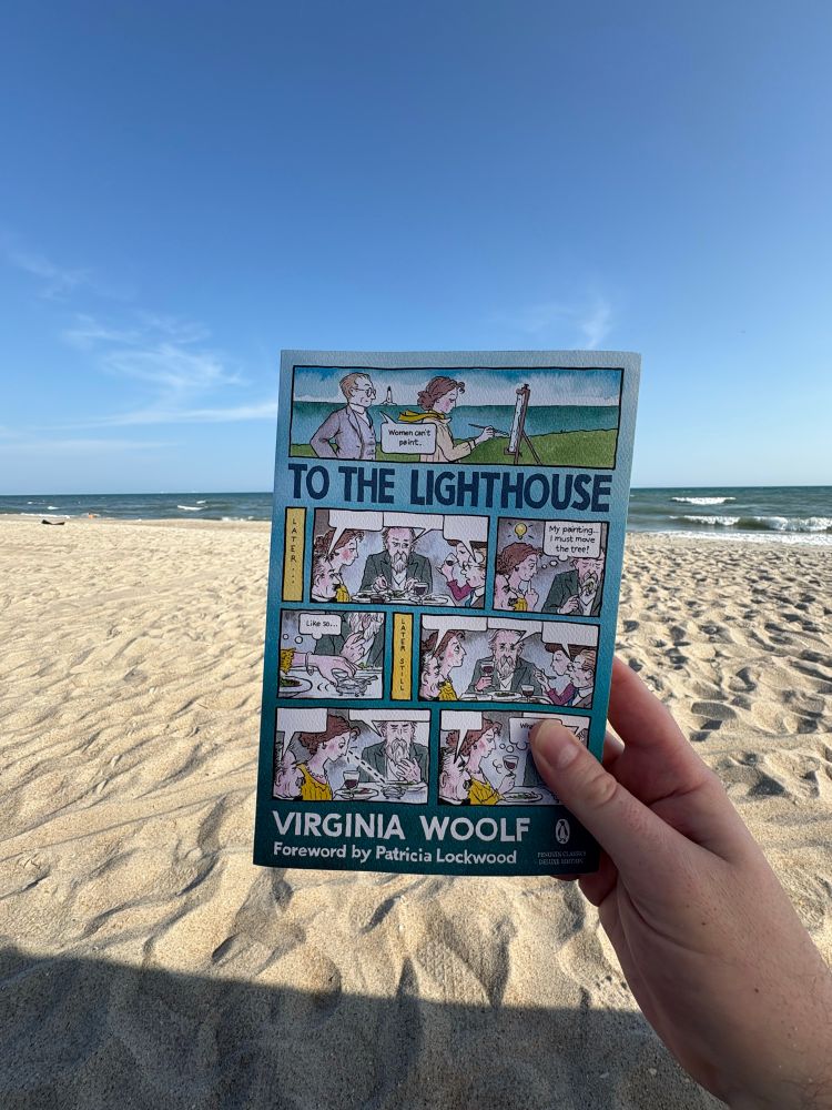 photo of a beach landscape; in the foreground is my right hand holding a paperback copy of Virginia Woolf’s To the Lighthouse 