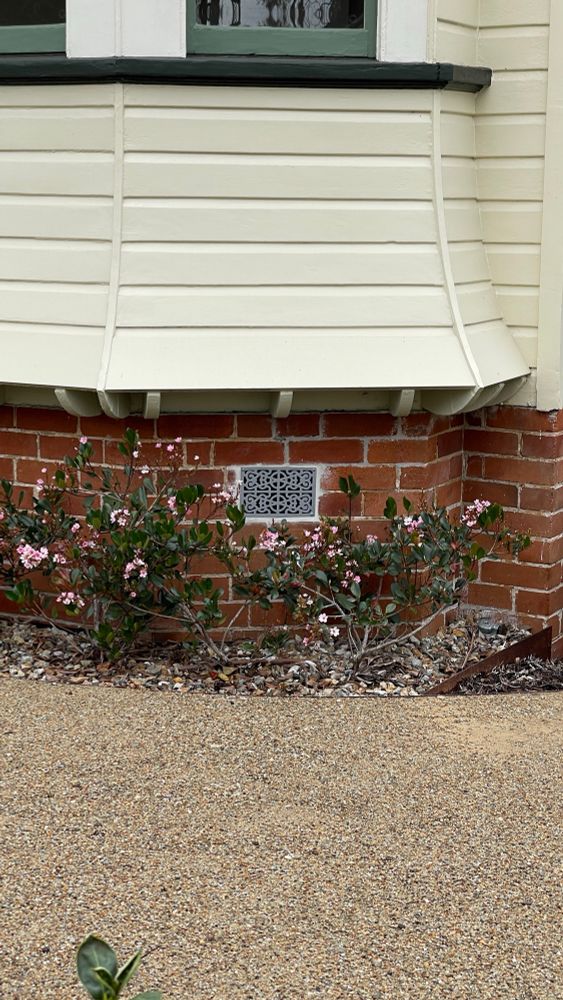 A photograph of an ironwork grill in the middle of a brick wall