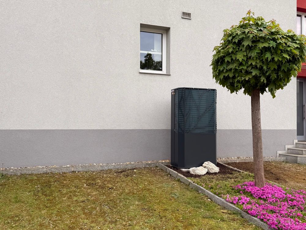 Aussengerät einer Lambda Wärmepumpe vor einem Haus aufgestellt. 