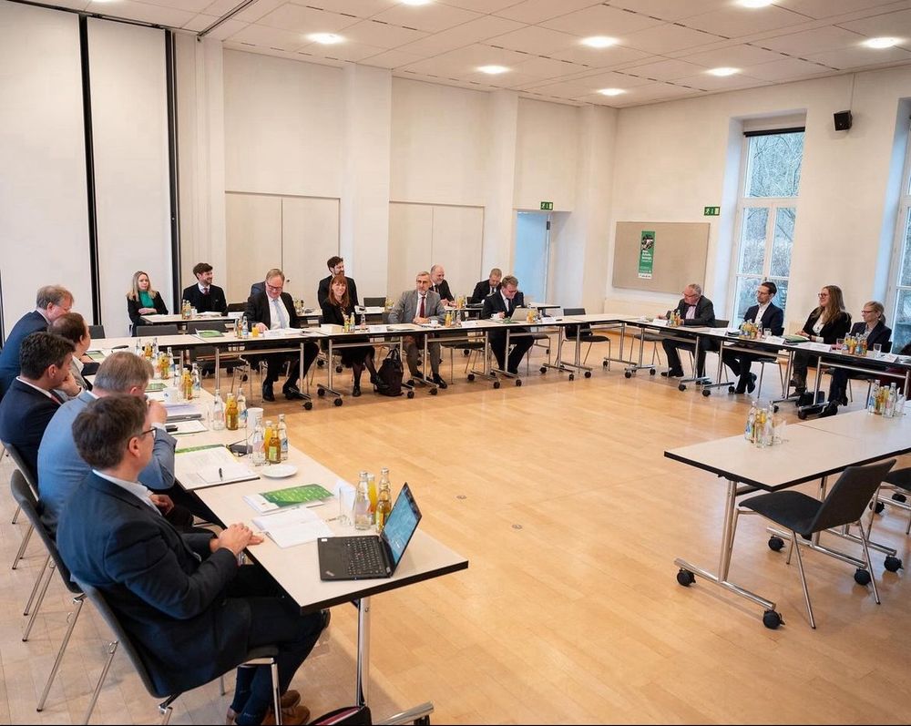 Teilnehmende am Sicherheitsgipfel sitzen an Tischen. Foto: SMJusDEG