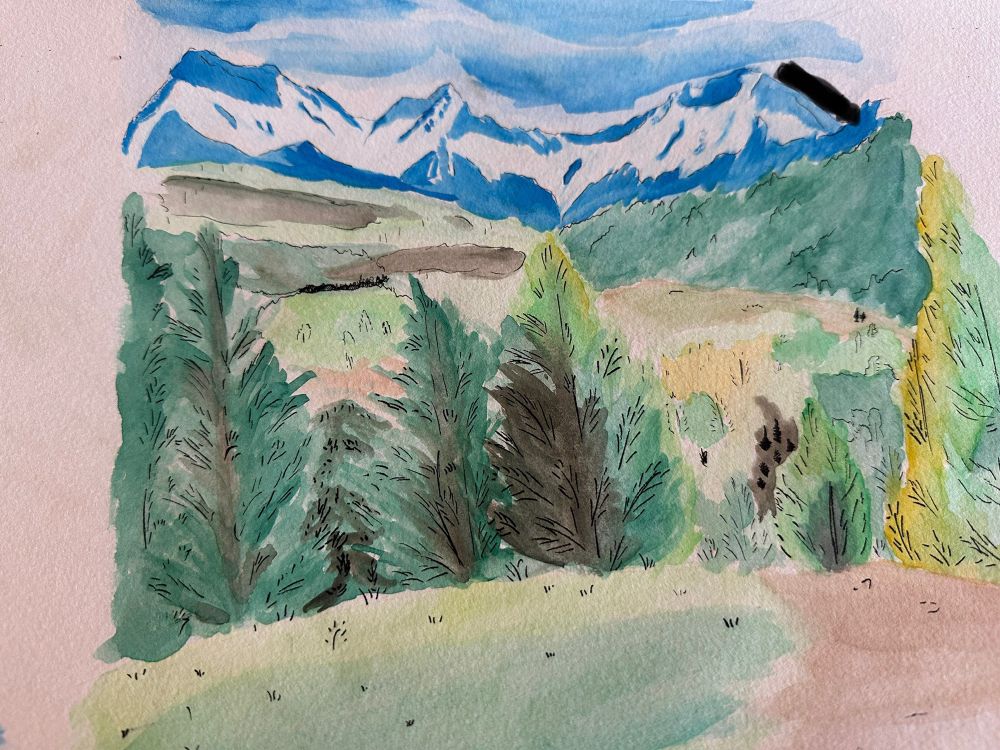 A forest and hilled landscape with mountains far off in the horizon