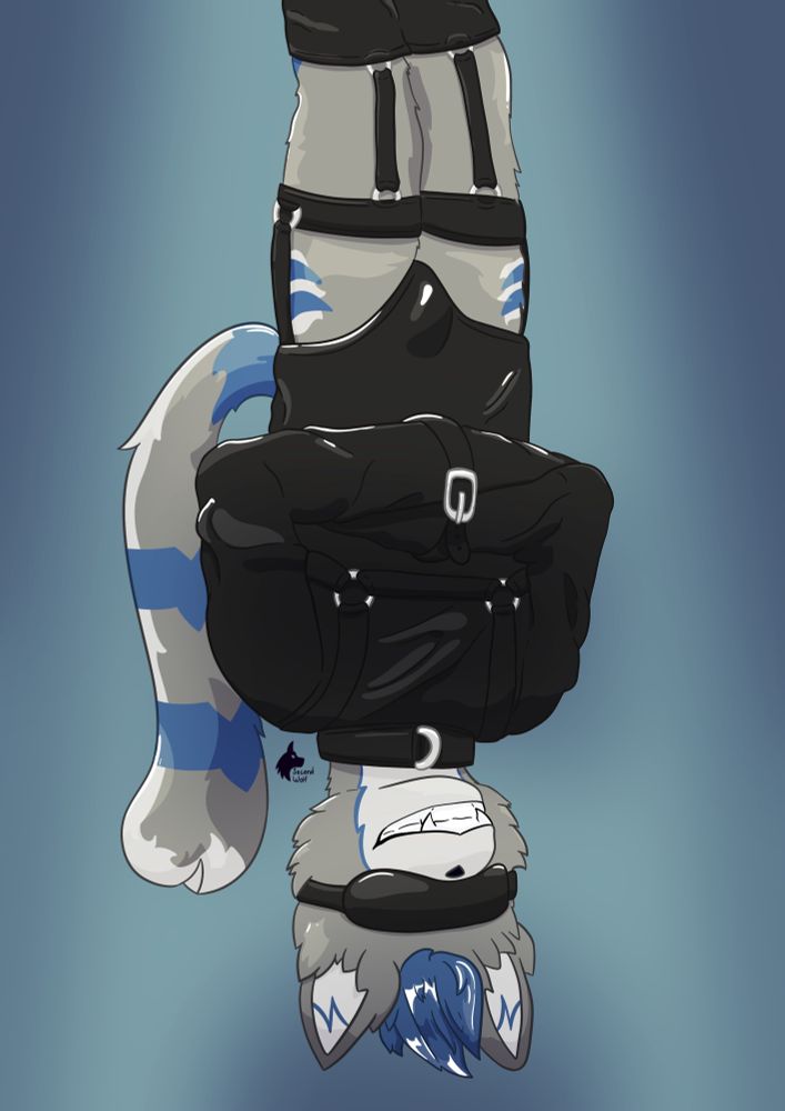 Wolf strung upside down in a black leather straight jacket as a spotlight shines down on him. He smiles wide, enjoying the situation