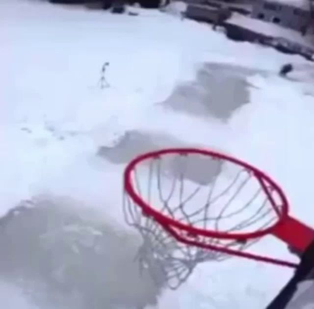 a person is jumping over a basketball hoop in the snow ..