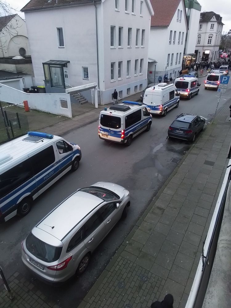 Sieben Polizeiwagen begleiten ca. 20 grölende Fußballkrawallmenschen durch die Bielefelder Innenstadt