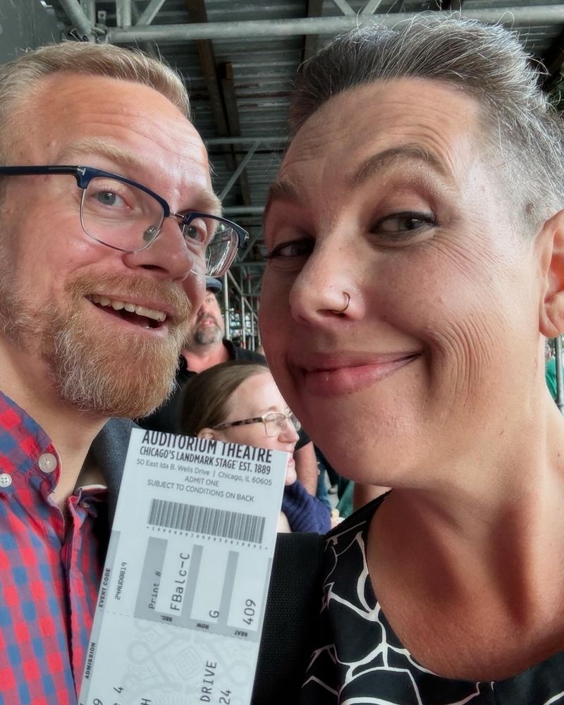 An old man and a young woman holding theatre tickets to Stephen Colbert at the Auditorium Theatre, Chicago.