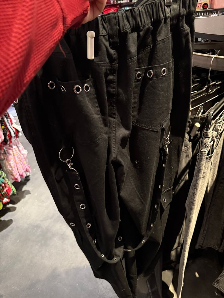 A pair of goth sweatpants with buckles and suspenders that loop around the pants (back view)