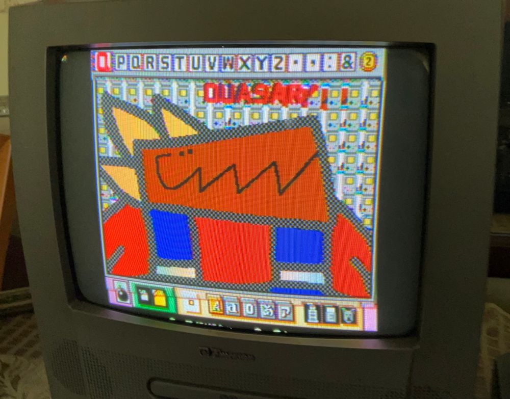 A drawing of a dinosaur like creature drawn on Mario Paint shown on a grey CRT tv. She has an underbite, has a red shirt plus overalls, an underbite and looks very happy.