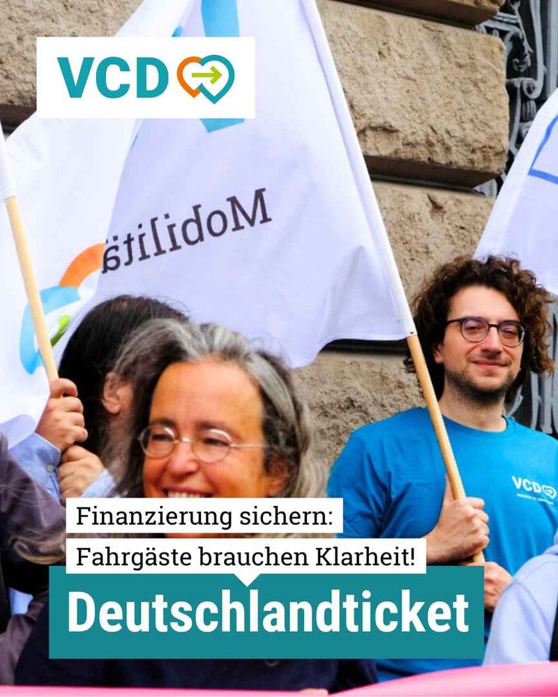 Finanzierung sichern: Fahrgäste brauchen Klarheit! Deutschlandticket. Links oben ist das VCD-Logo und im Hintergrund sieht man ein Foto einer Demo des VCDs und anderer Verbände anlässlich der Sonder-Verkehrsministerkonferenz.