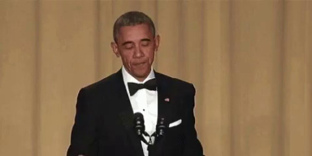 a man in a tuxedo is holding a microphone in his hand