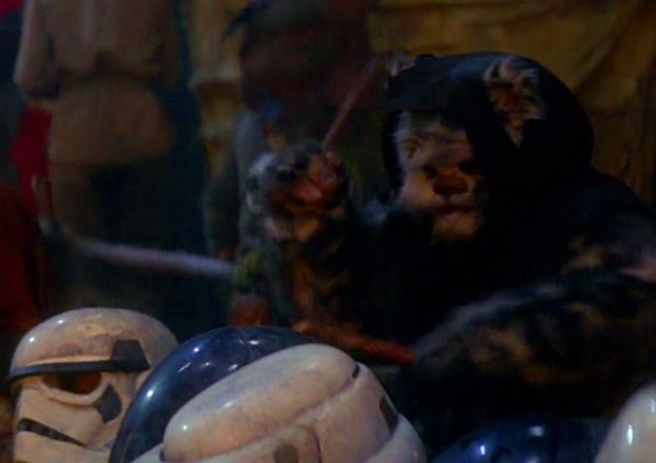 An ewok drumming on empty stormtrooper helmets, having presumably feasted on the goo within 