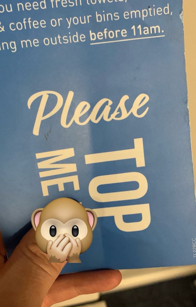 Close up of a hotel door handle sign saying “Please TOP ME…..” with a thumb over the word that follows ‘me’.