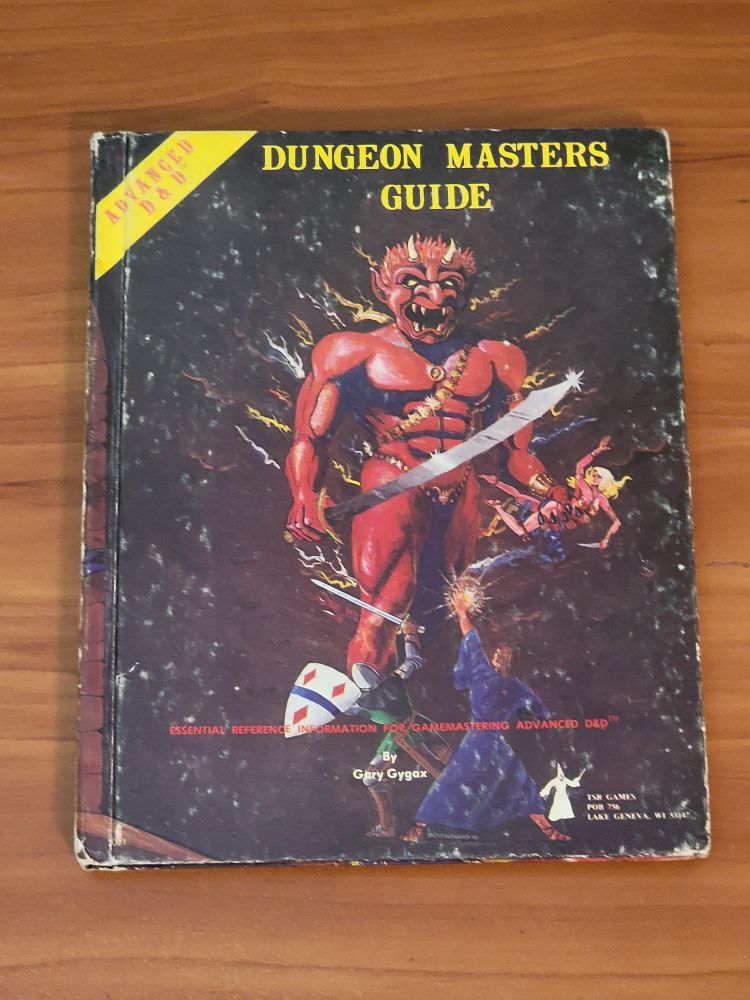 AD&D Dungeon Master's Guide - by Gary Gygax. This is the original 1979 printing! Very scuffed up looking book with some damage to the corners, but still holding together just fine.