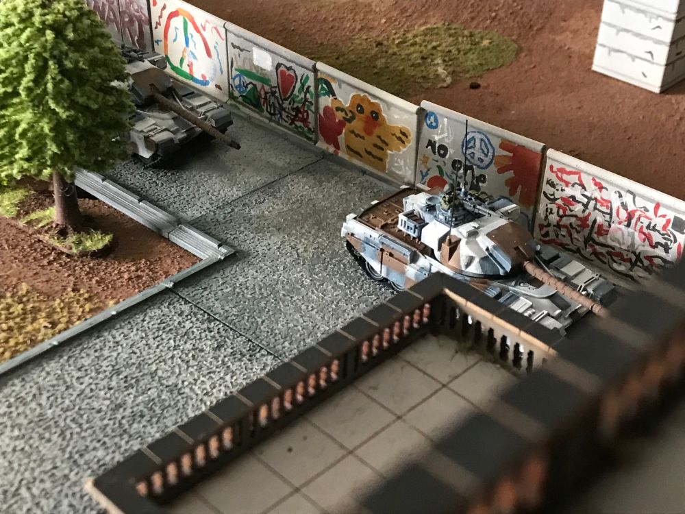 14/20th hussars pass brightly coloured panels of the Berlin Wall, many have the CND symbol. One has a large yellow bird Mural. 