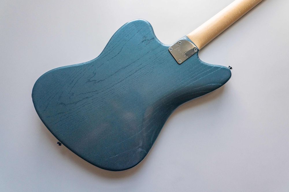 A teal blue offset electric guitar, back. 