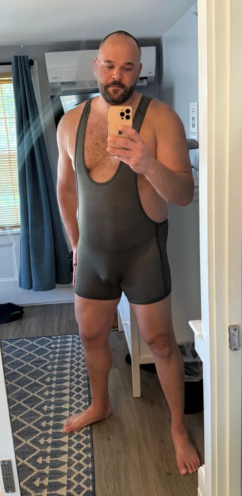 Multiracial man wearing an olive green singlet. 