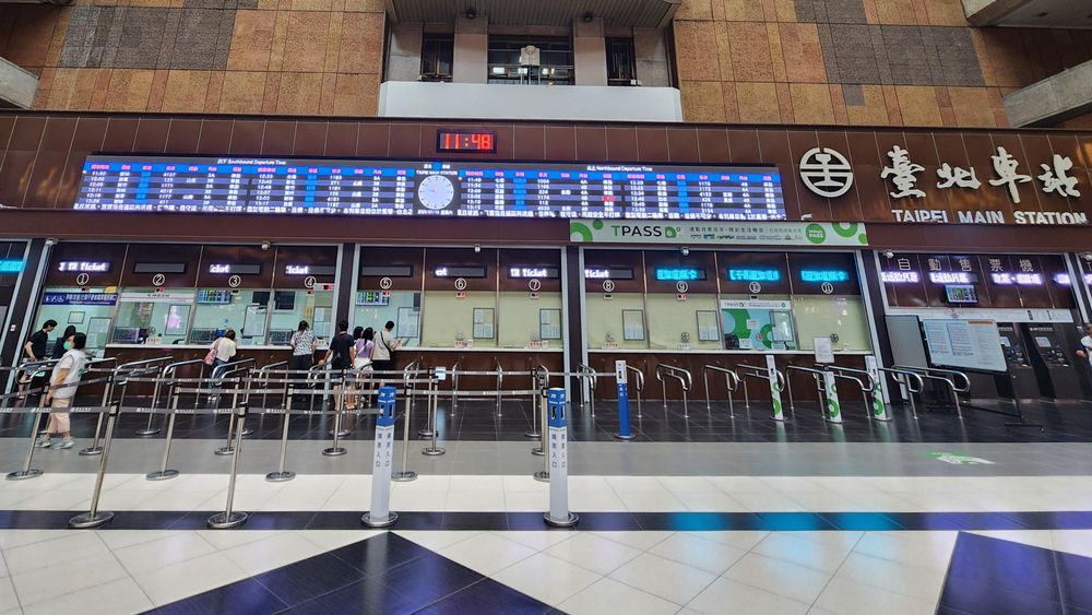 Taipei main station with a digital departure board. Checkerboard floor.