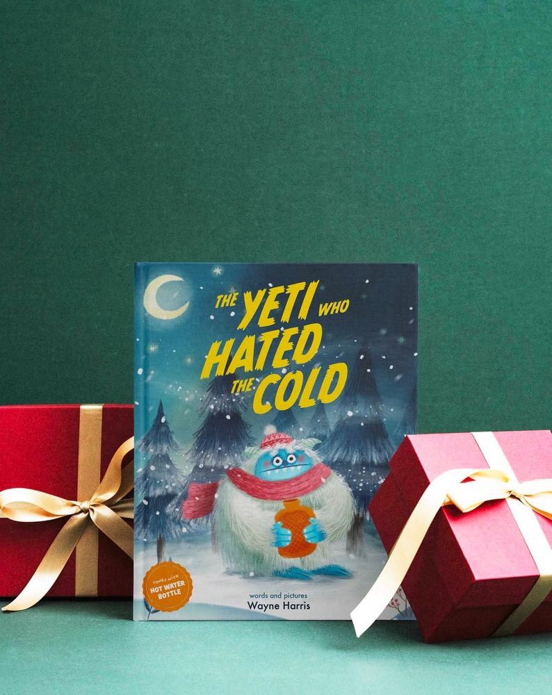 Mockup. Cover of an imagined childrens book called The Yeti who hated the cold. A cold looking yeti, wearing a red scarf and bobble hat clutches an orange hot water bottle tightly. Snow is blowing. Trees are in the background. 