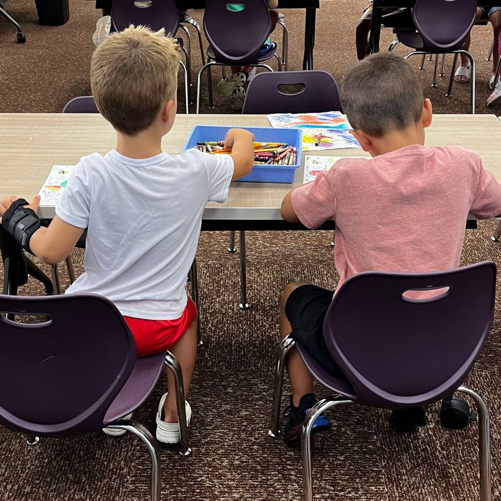 Two boys coloring together.