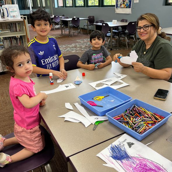 Family of four crafting and smiling.