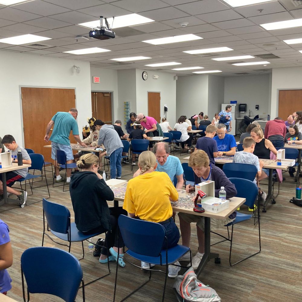 Teams of people putting together puzzles.