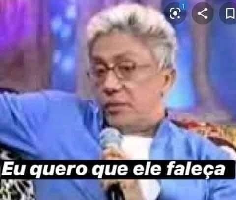 Clorofila segurando um microfone com cara de desanimado e a legenda eu quero que ele faleça 