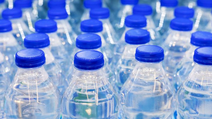 Rows of bottled water with blue tops
